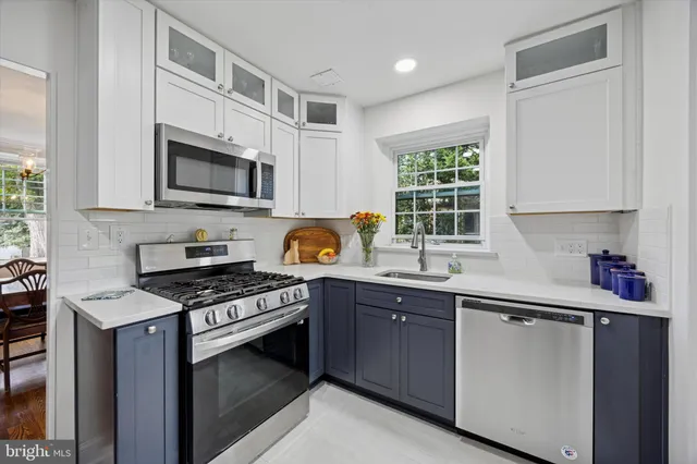 a kitchen with stainless steel appliances a sink stove microwave and cabinets