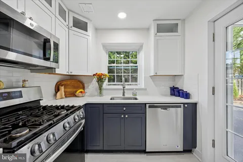 a kitchen with stainless steel appliances granite countertop a stove a sink and a microwave