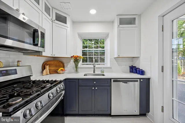 a kitchen with stainless steel appliances granite countertop a stove a sink and a microwave