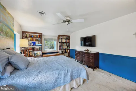 a spacious bedroom with a bed and a flat screen tv
