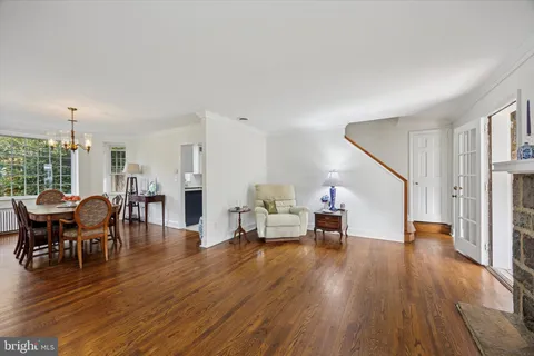 a living room with furniture dining table and wooden floor