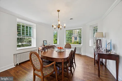 a dining room with furniture a chandelier and wooden floor
