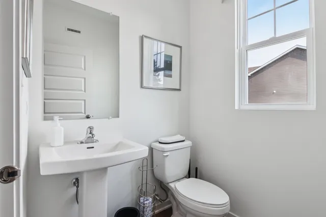 a bathroom with a sink mirror and toilet