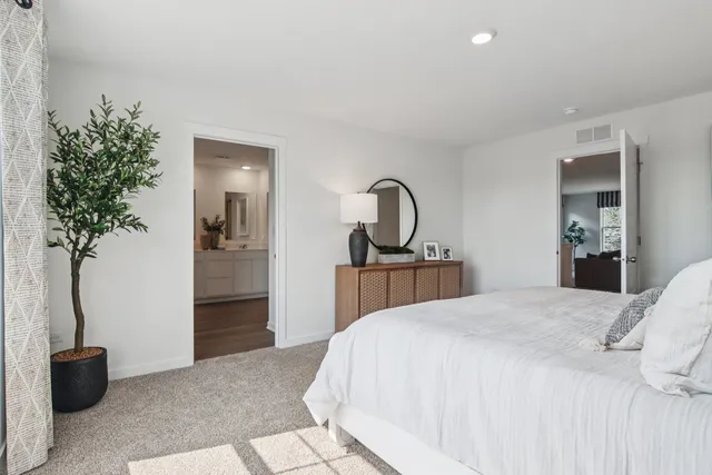 a bedroom with a bed and a potted plant