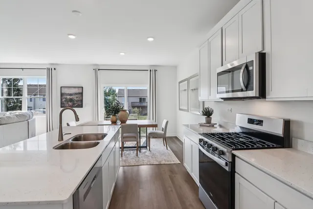 a kitchen with stainless steel appliances granite countertop a sink stove and microwave