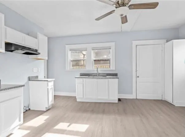 a kitchen with white cabinets and white appliances