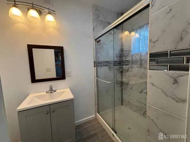 a bathroom with a shower sink and mirror