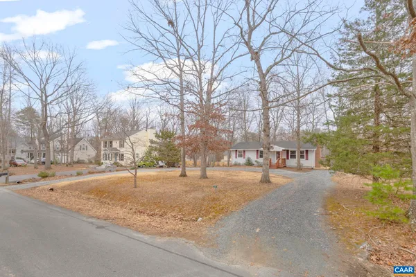 a front view of a house with a yard and large trees
