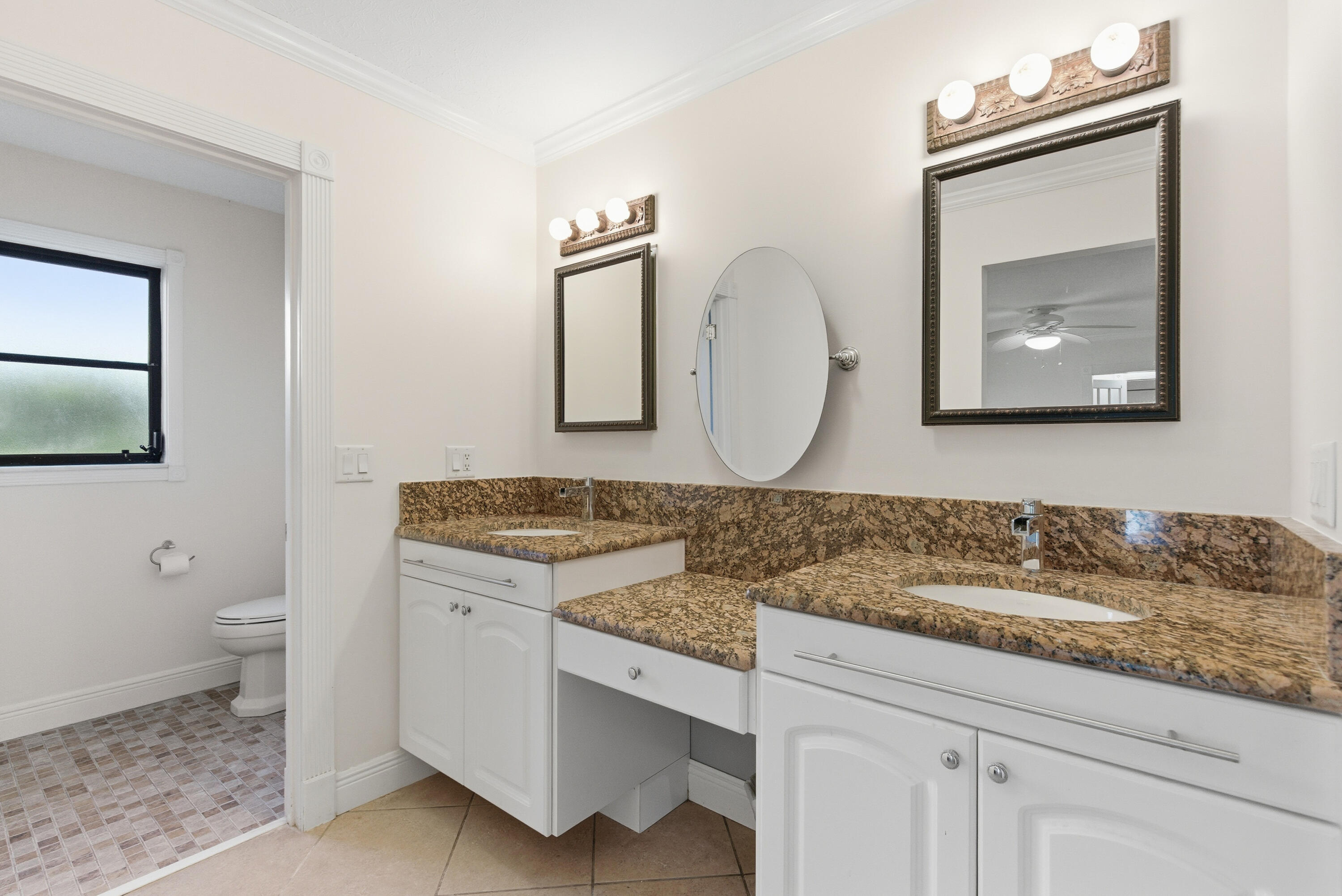 5151 Southeast Burning Tree Circle Stuart, FL 34997 - Photo 31 of 74 a bathroom with a toilet sink and mirror