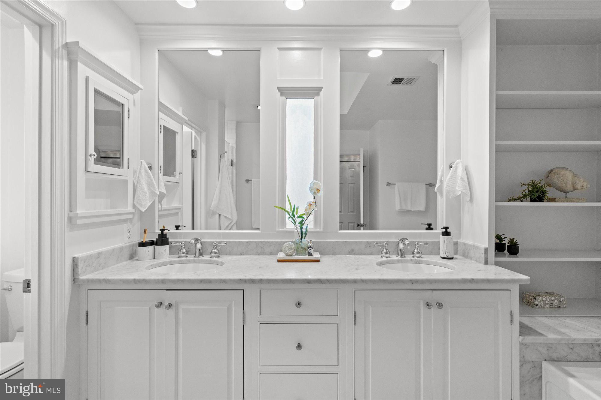 7287 Evans Mill Road McLean, VA 22101 - Photo 18 of 30 a bathroom with double vanity sinks and a mirror