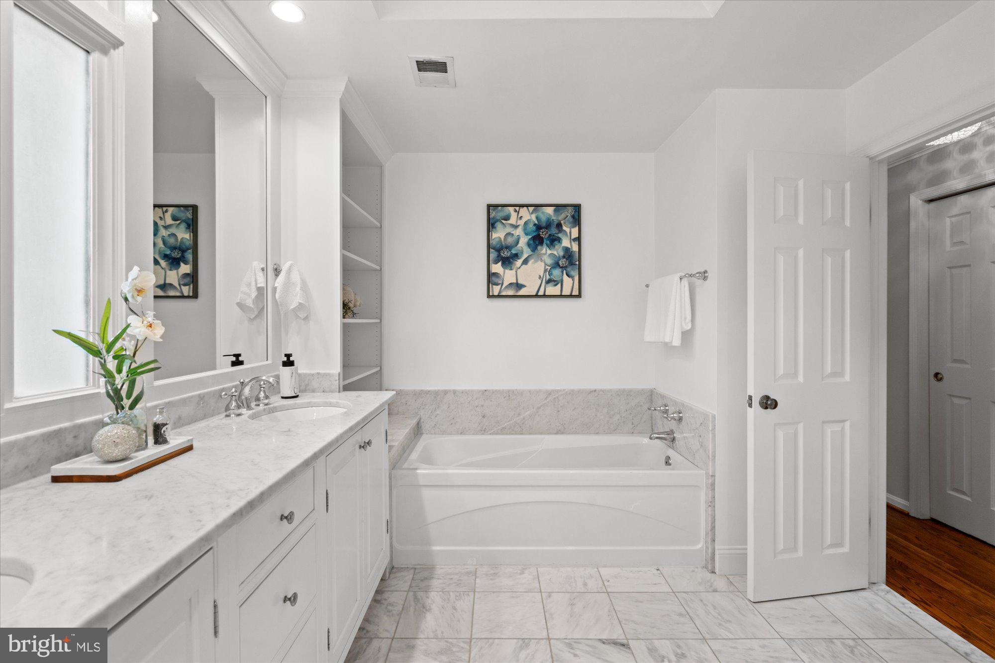 7287 Evans Mill Road McLean, VA 22101 - Photo 20 of 30 a bathroom with a granite countertop bathtub sink vanity and mirror