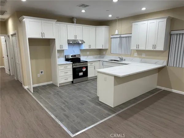 a kitchen with a refrigerator sink and cabinets