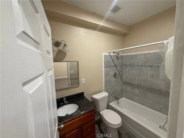a bathroom with a granite countertop toilet sink and shower