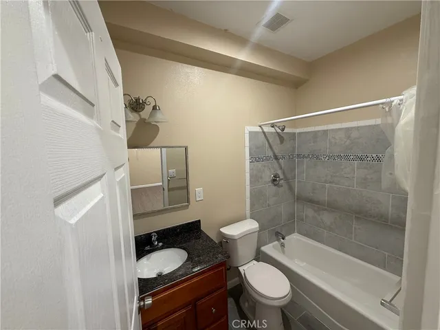 a bathroom with a granite countertop toilet sink and shower
