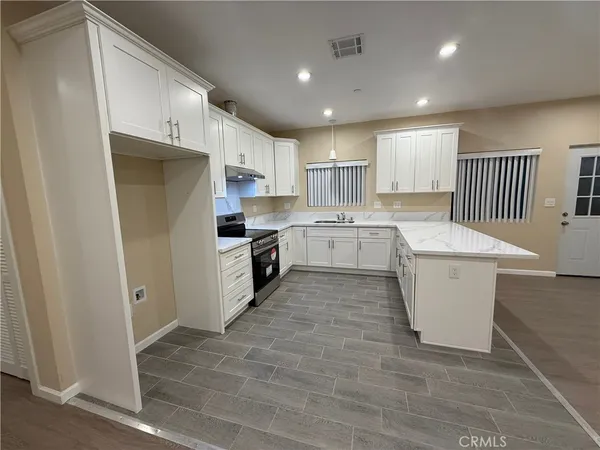 a kitchen with white cabinets and white appliances