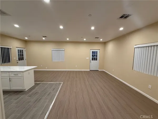a view of a kitchen with wooden floor and a sink