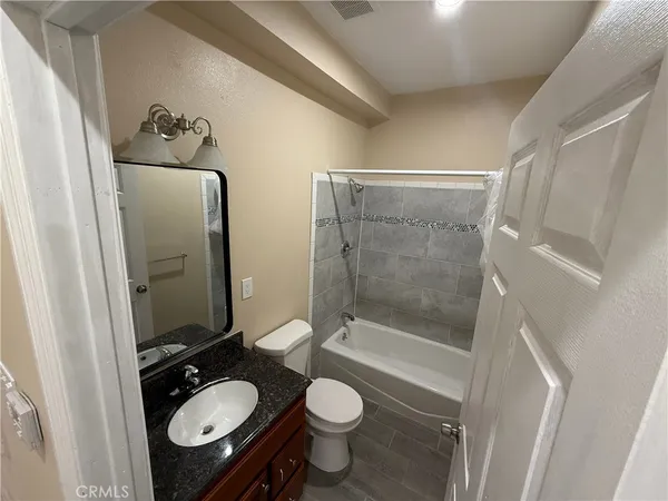 a bathroom with a granite countertop toilet sink and shower