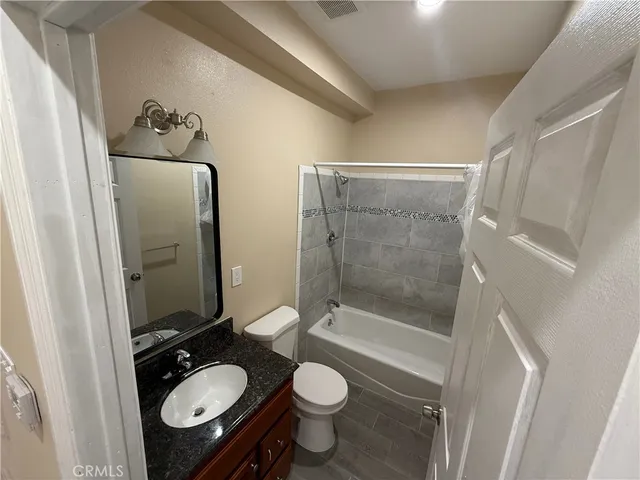a bathroom with a granite countertop toilet sink and shower