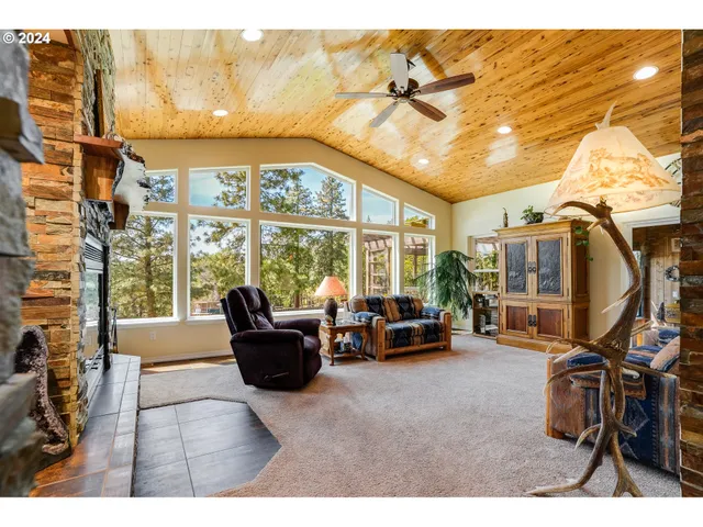 a living room with furniture a flat screen tv and a floor to ceiling window