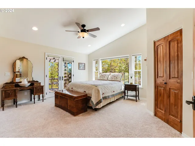 a spacious bedroom with a bed a window and couch