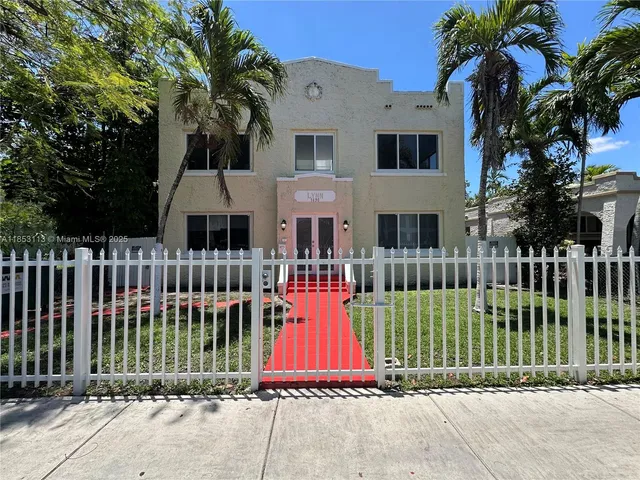 a view of a brick house with a small yard and plants