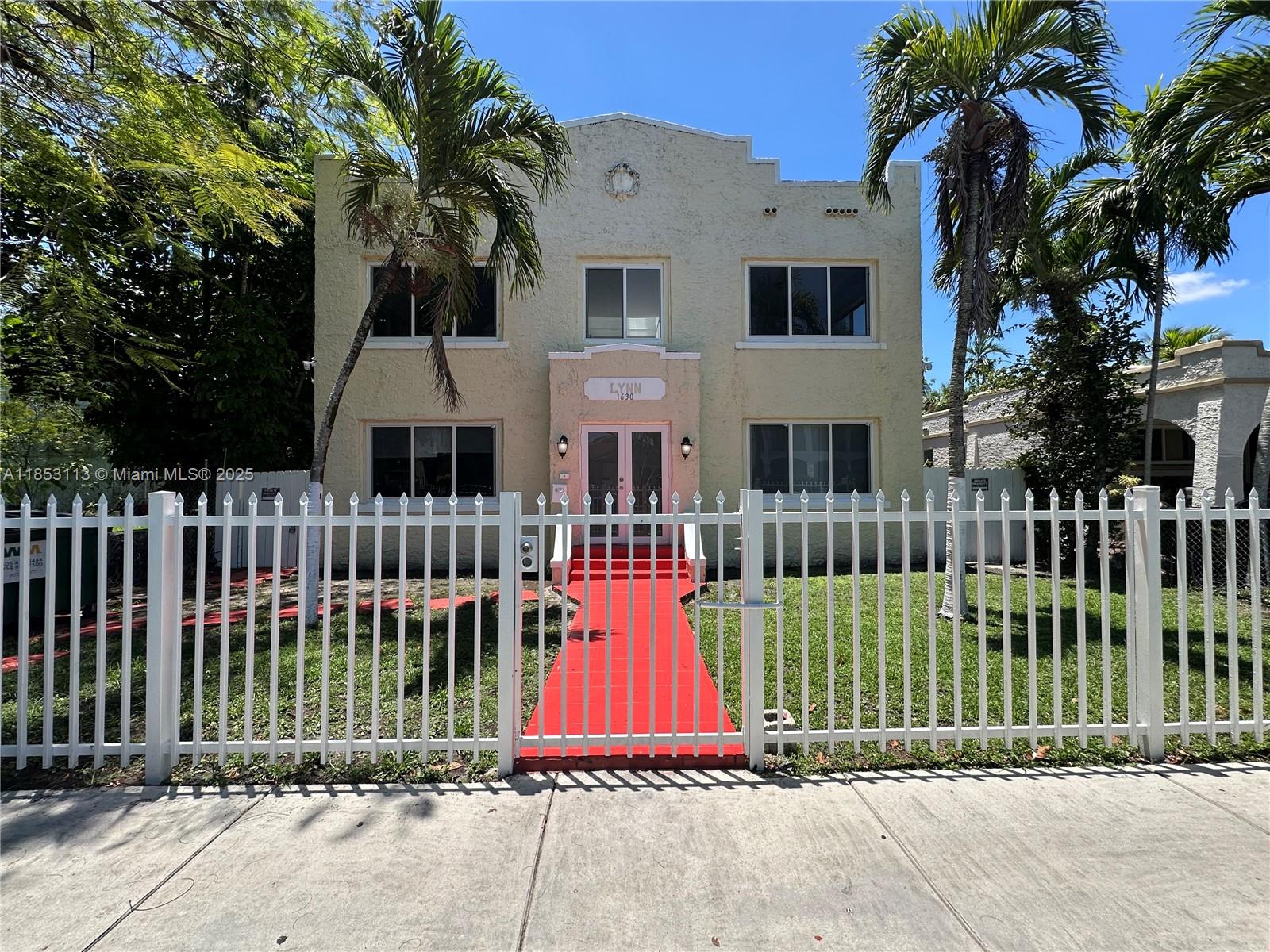 a view of a brick house with a small yard and plants