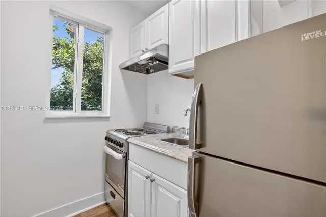 a kitchen with a stove a sink and a window