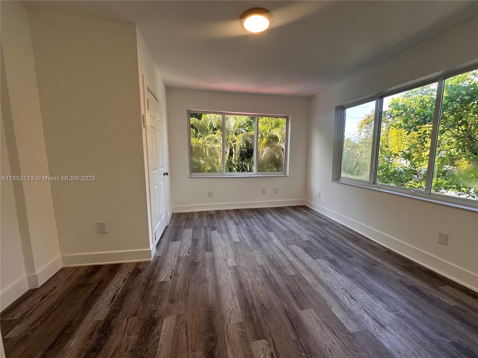 1630 Southwest 10th Street, Unit 8 Miami, FL 33135 - Photo 5 of 14 an empty room with wooden floor and windows