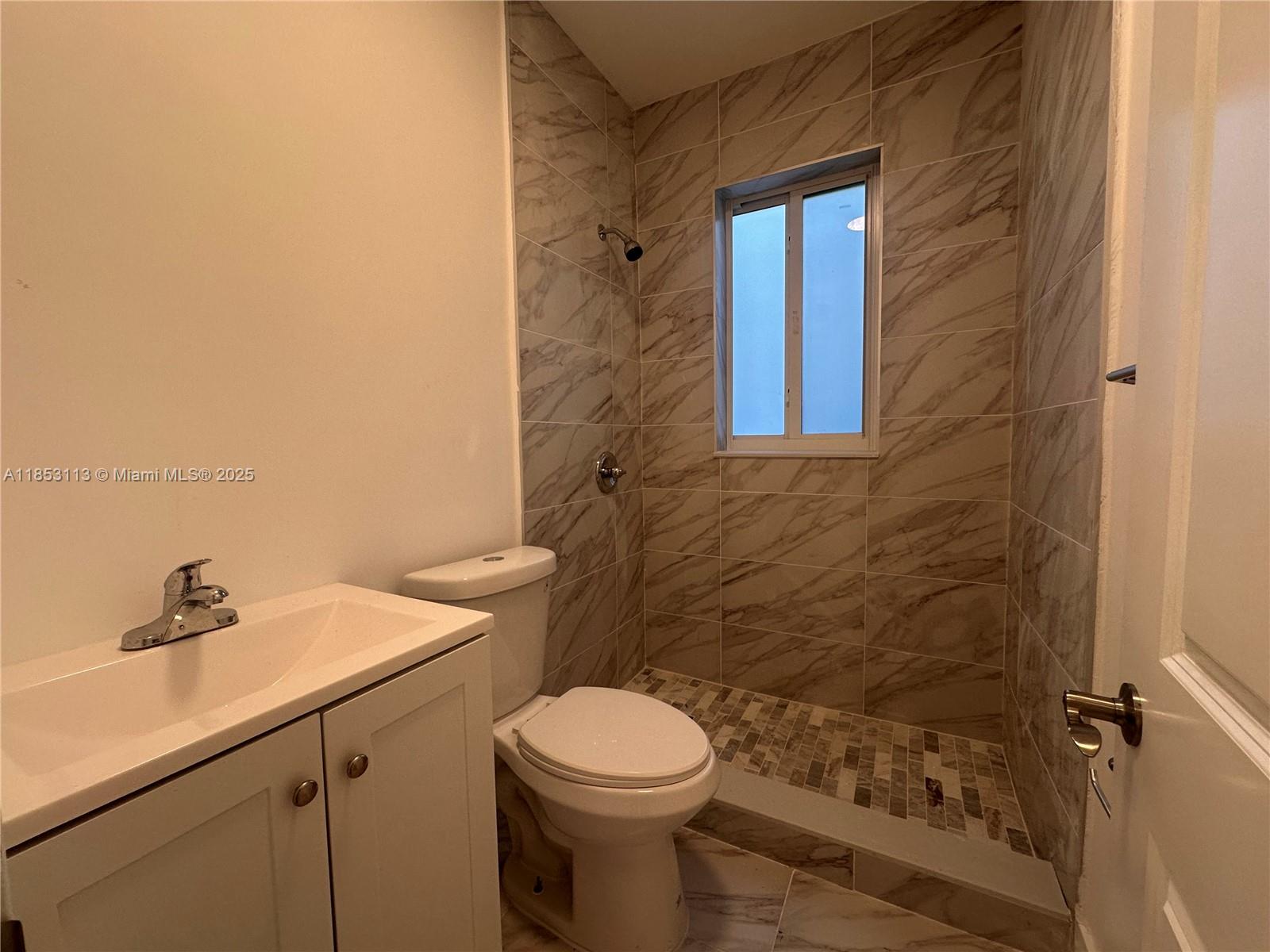 1630 Southwest 10th Street, Unit 8 Miami, FL 33135 - Photo 9 of 14 a bathroom with a sink a toilet and shower