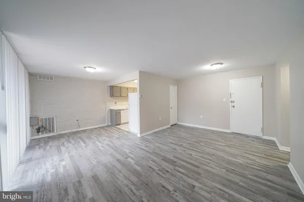 a view of empty room with wooden floor