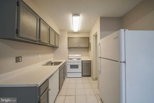 a kitchen with a sink a refrigerator and cabinets