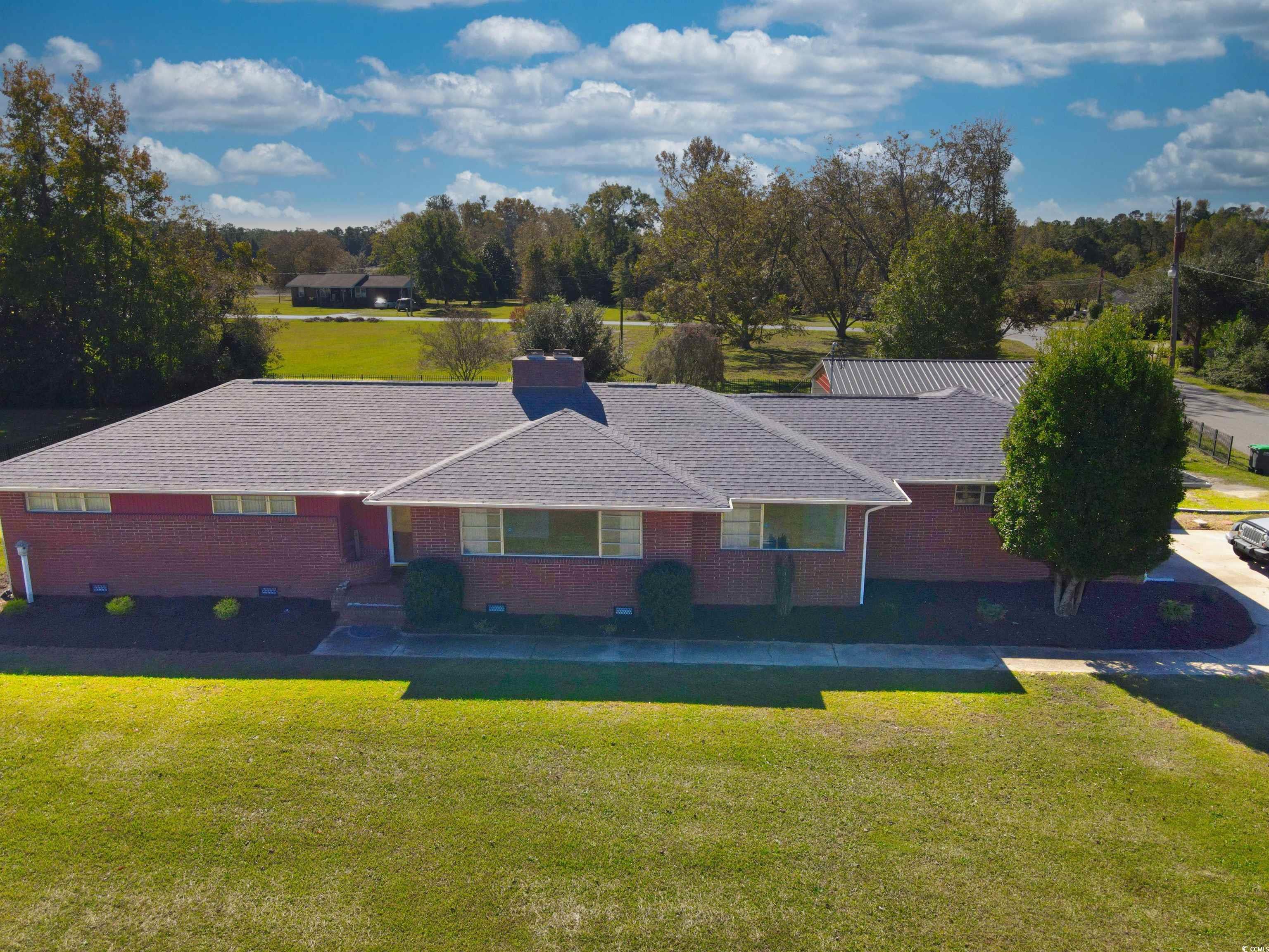 View of front of home with a front lawn, brick siding, and a porch