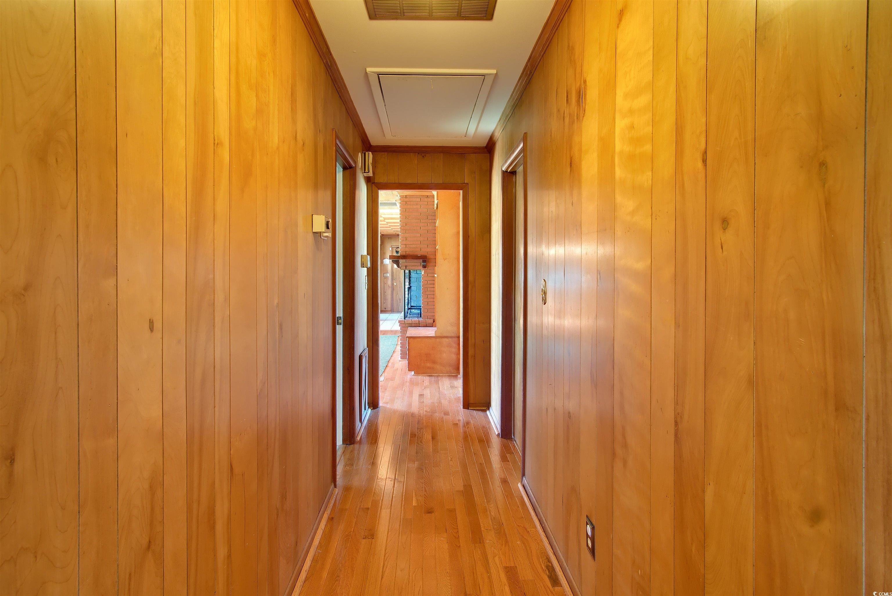5408 Main Street Loris, SC 29569 - Photo 16 of 20 Corridor featuring light wood-type flooring, wood walls, and crown molding