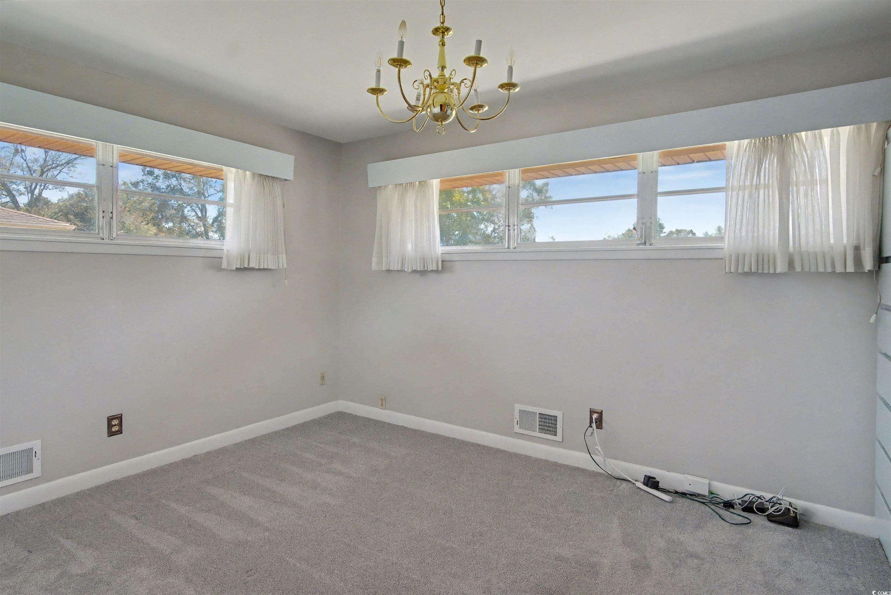 5408 Main Street Loris, SC 29569 - Photo 17 of 20 Spare room featuring carpet floors and a chandelier