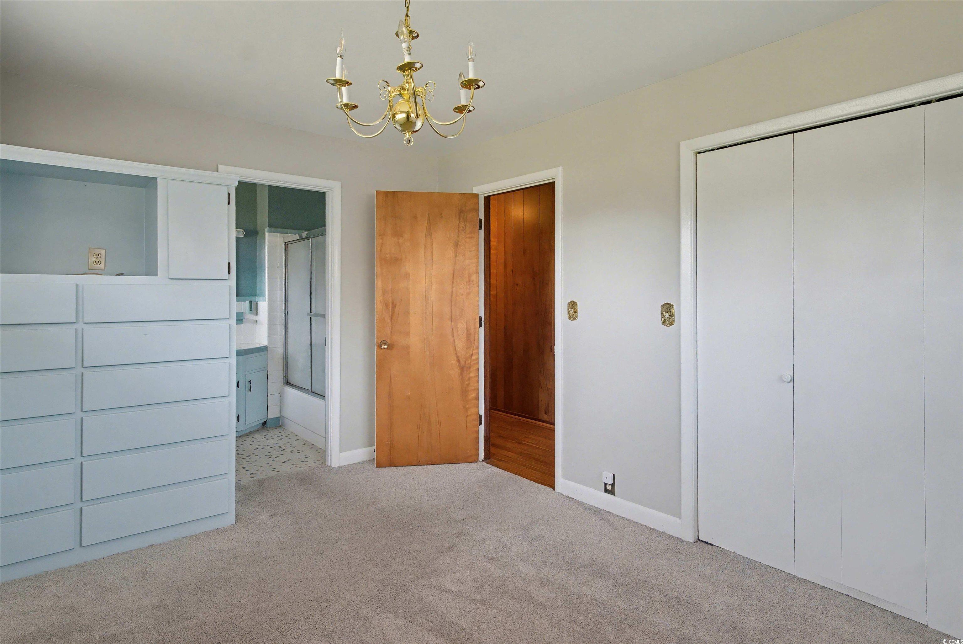 5408 Main Street Loris, SC 29569 - Photo 18 of 20 Unfurnished bedroom with a chandelier, a closet, carpet, and ensuite bath
