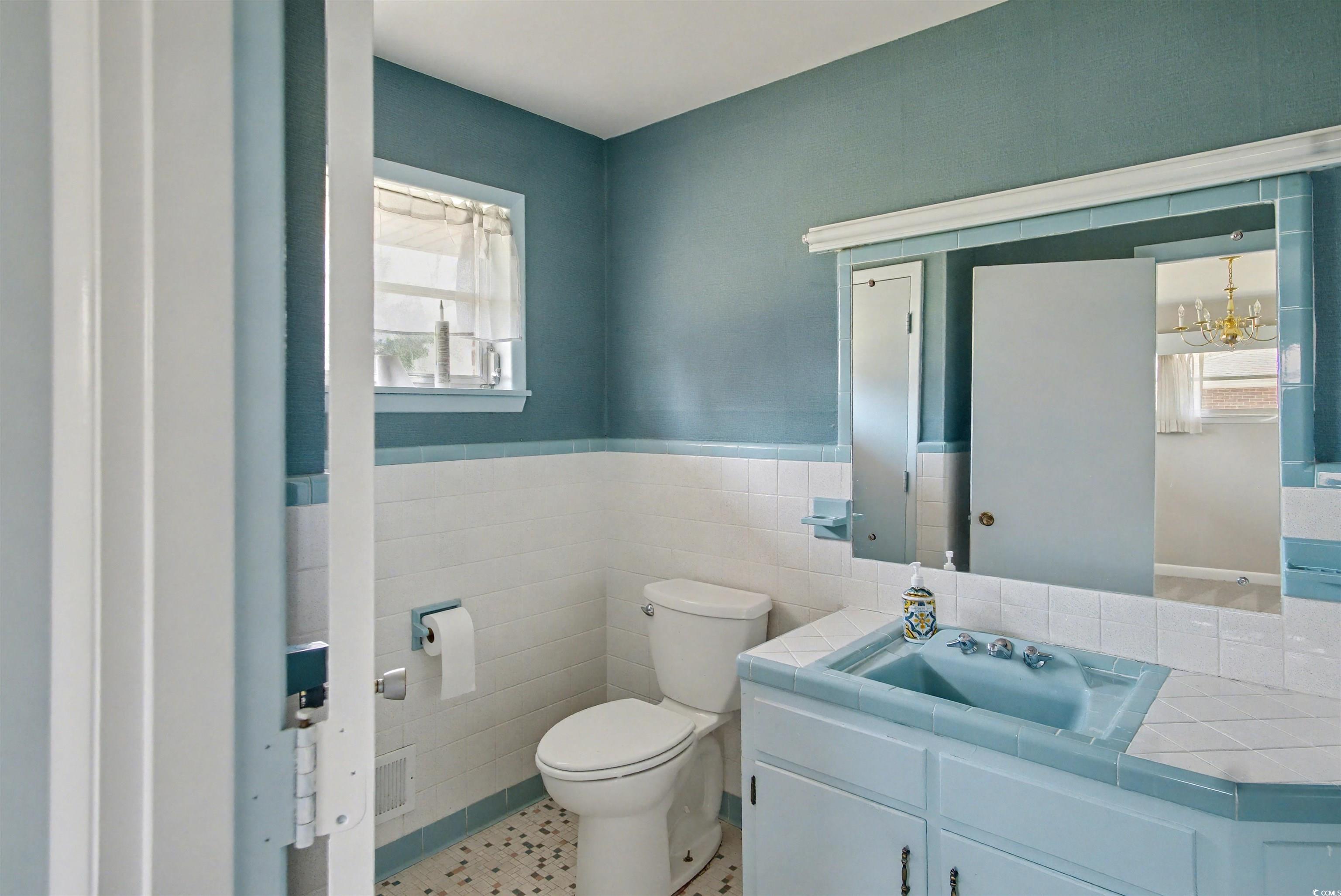 5408 Main Street Loris, SC 29569 - Photo 19 of 20 Half bathroom with tile walls, vanity, a chandelier, and wainscoting