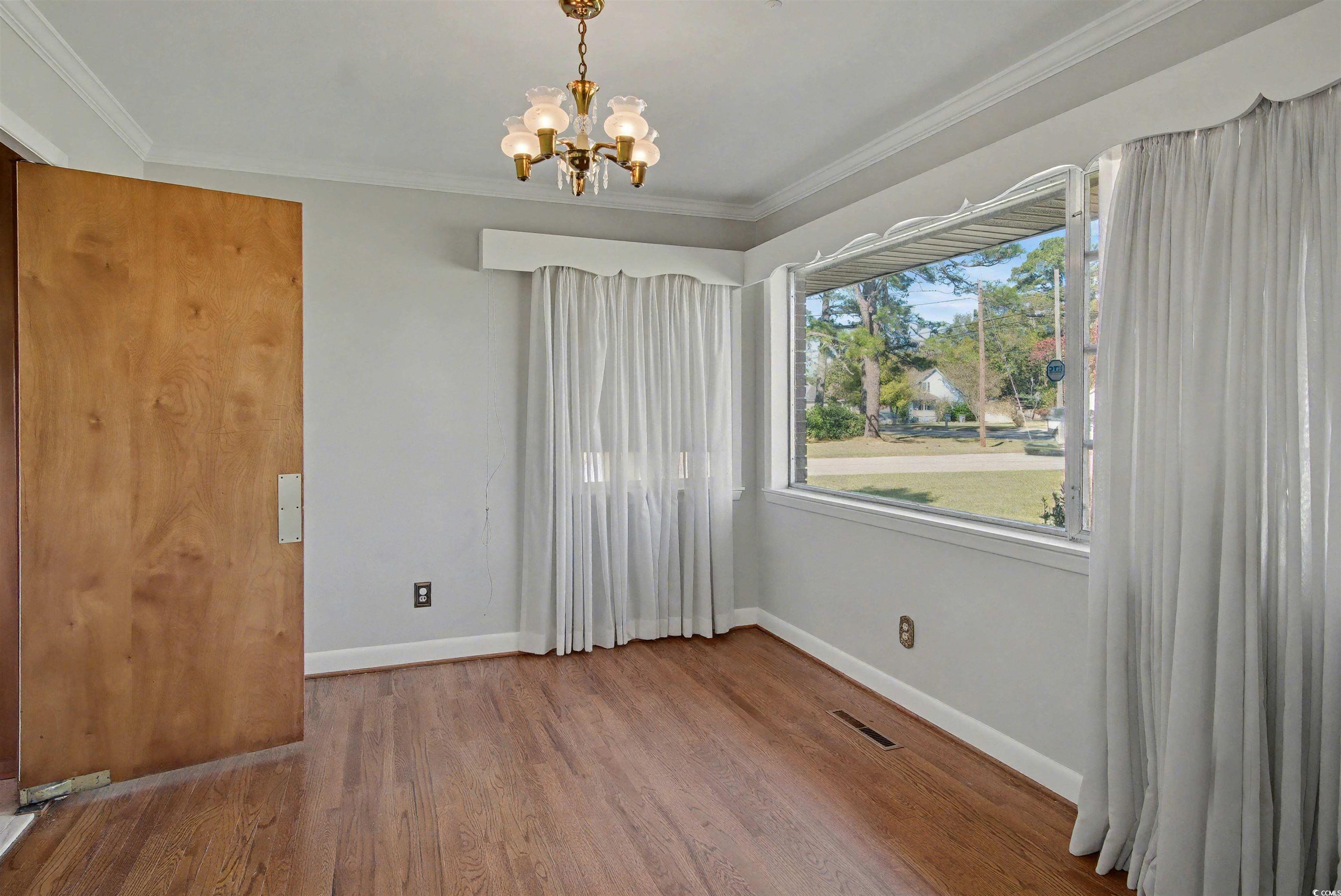 5408 Main Street Loris, SC 29569 - Photo 8 of 20 Unfurnished dining area featuring wood finished floors, a chandelier, and ornamental molding