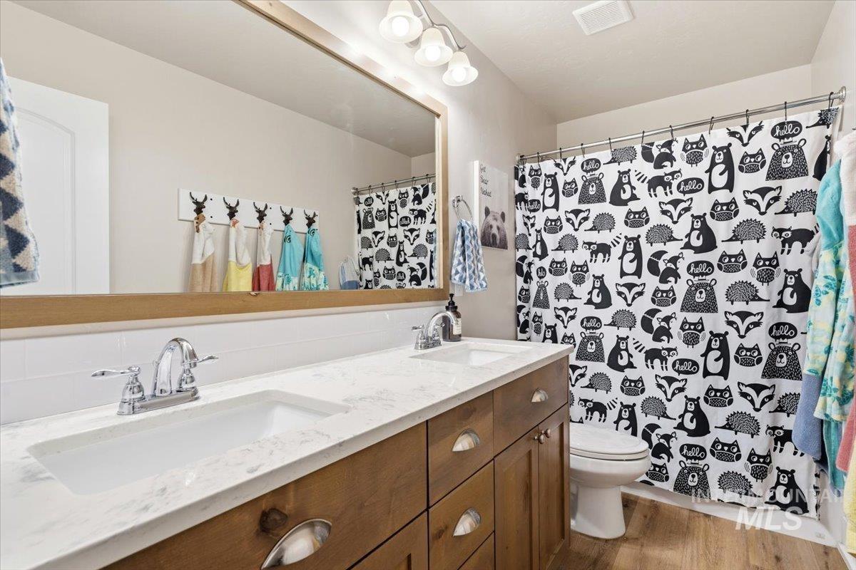 1282 Cimarron Court Middleton, ID 83644 - Photo 22 of 44 Bathroom with double vanity, light wood-style floors, and curtained shower