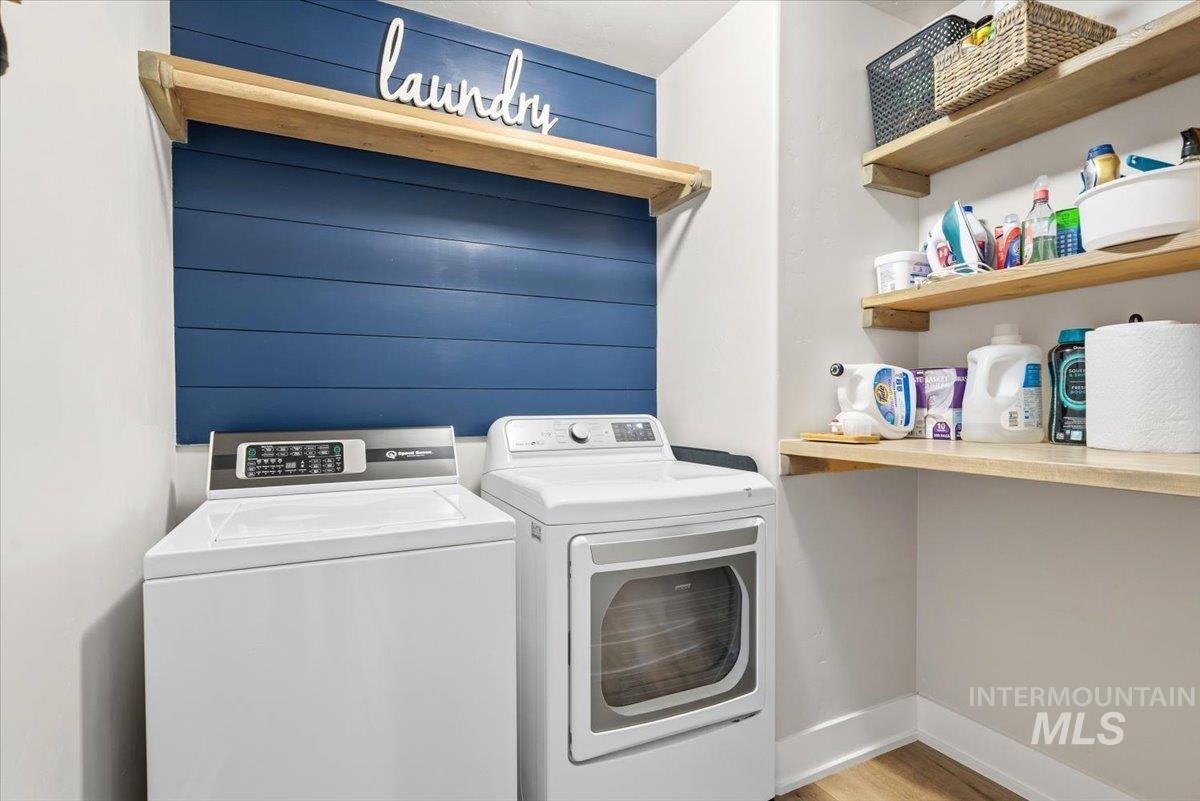 1282 Cimarron Court Middleton, ID 83644 - Photo 26 of 44 Laundry area featuring washing machine and dryer, light wood-style floors, and wood walls