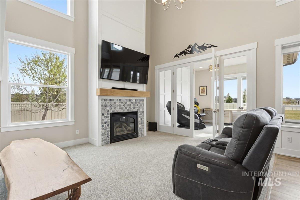 1282 Cimarron Court Middleton, ID 83644 - Photo 4 of 44 Living area with a high ceiling, french doors, a fireplace, light colored carpet, and suspended lighting