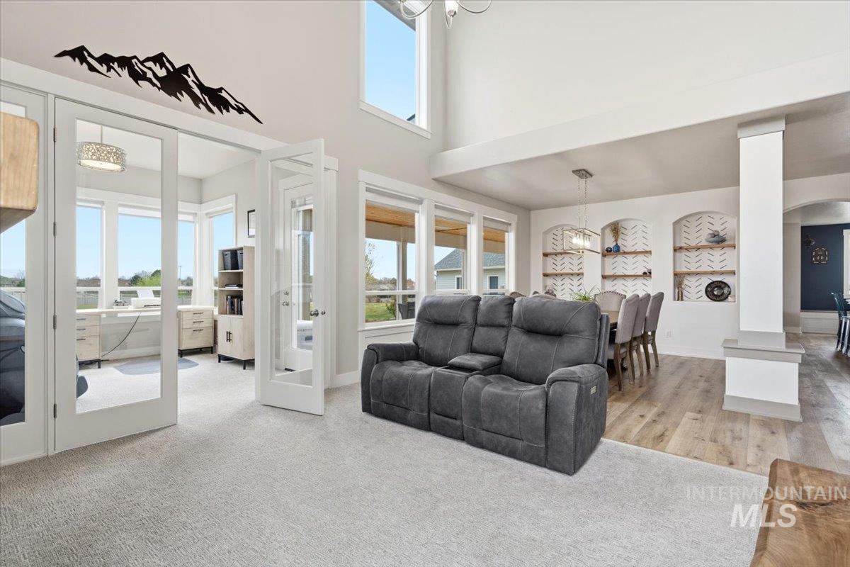 1282 Cimarron Court Middleton, ID 83644 - Photo 6 of 44 Living area featuring hanging lights, arched walkways, a high ceiling, and light colored carpet