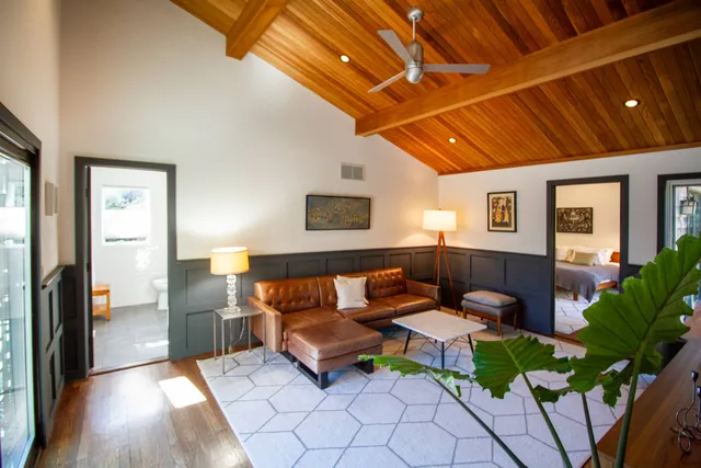 a living room with patio furniture and a potted plant