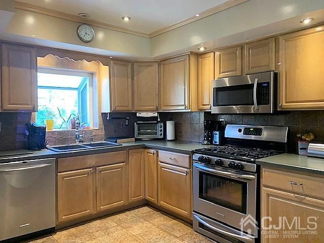 730 Center Street Dunellen, NJ 08812 - Photo 10 of 27 a kitchen with stainless steel appliances a stove a sink a stove cabinets and a window