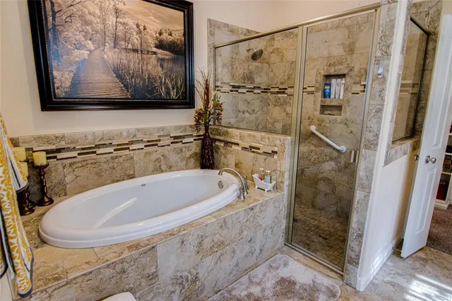 a bathroom with a tub a toilet and a shower