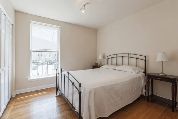 a bedroom with a bed and wooden floor