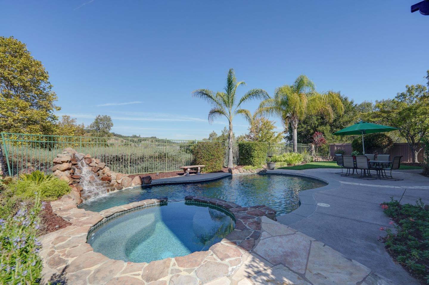 2400 Club Drive Gilroy, CA 95020 - Photo 58 of 67 a view of a swimming pool with lawn chairs under an umbrella