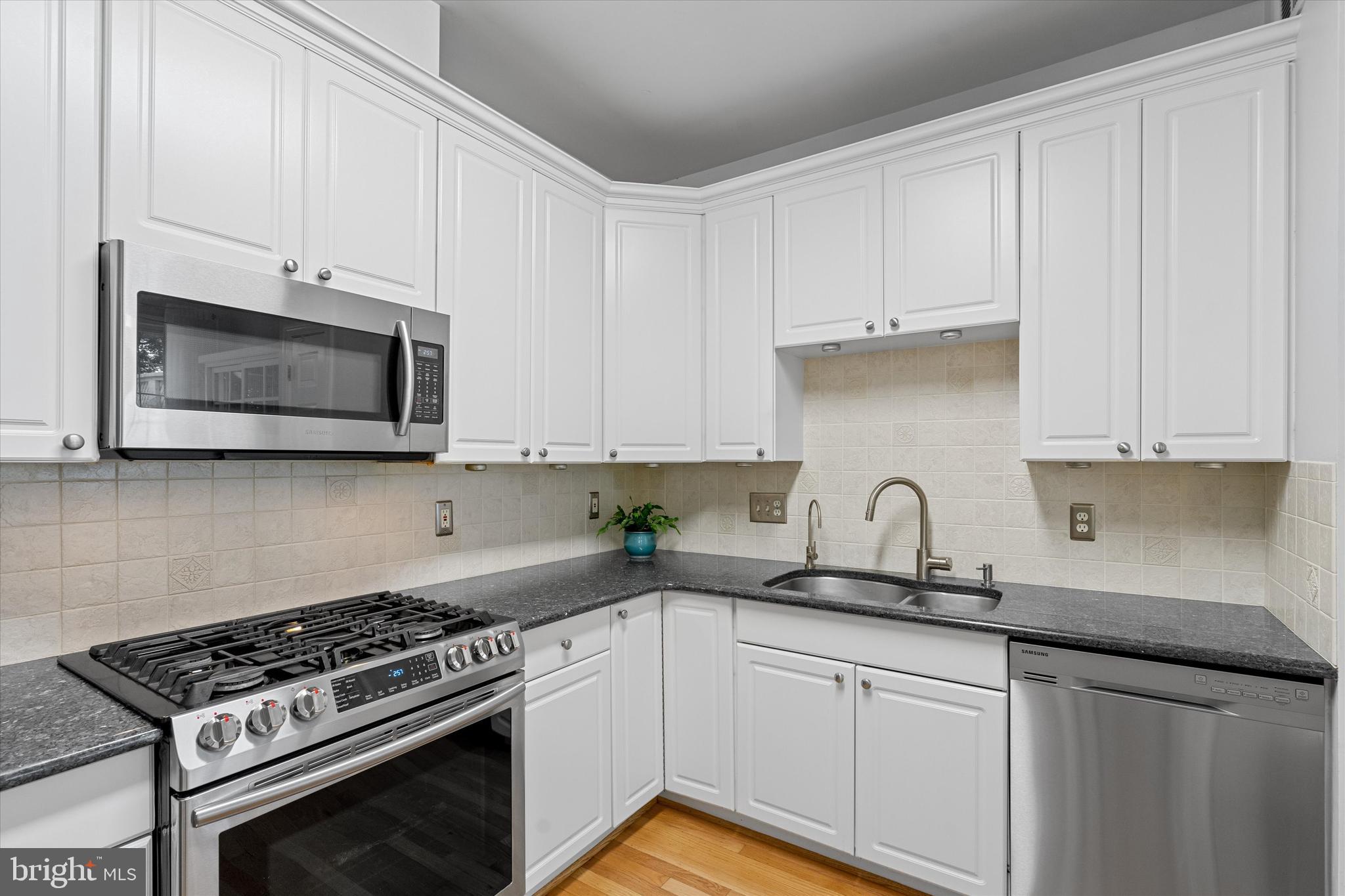 8512 Bells Ridge Terrace Potomac, MD 20854 - Photo 11 of 45 a kitchen with granite countertop white cabinets stainless steel appliances and sink