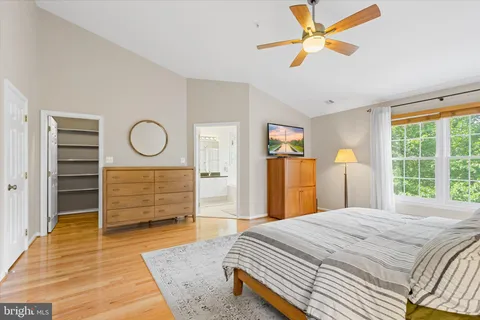 a bedroom with a bed a couch and a large window