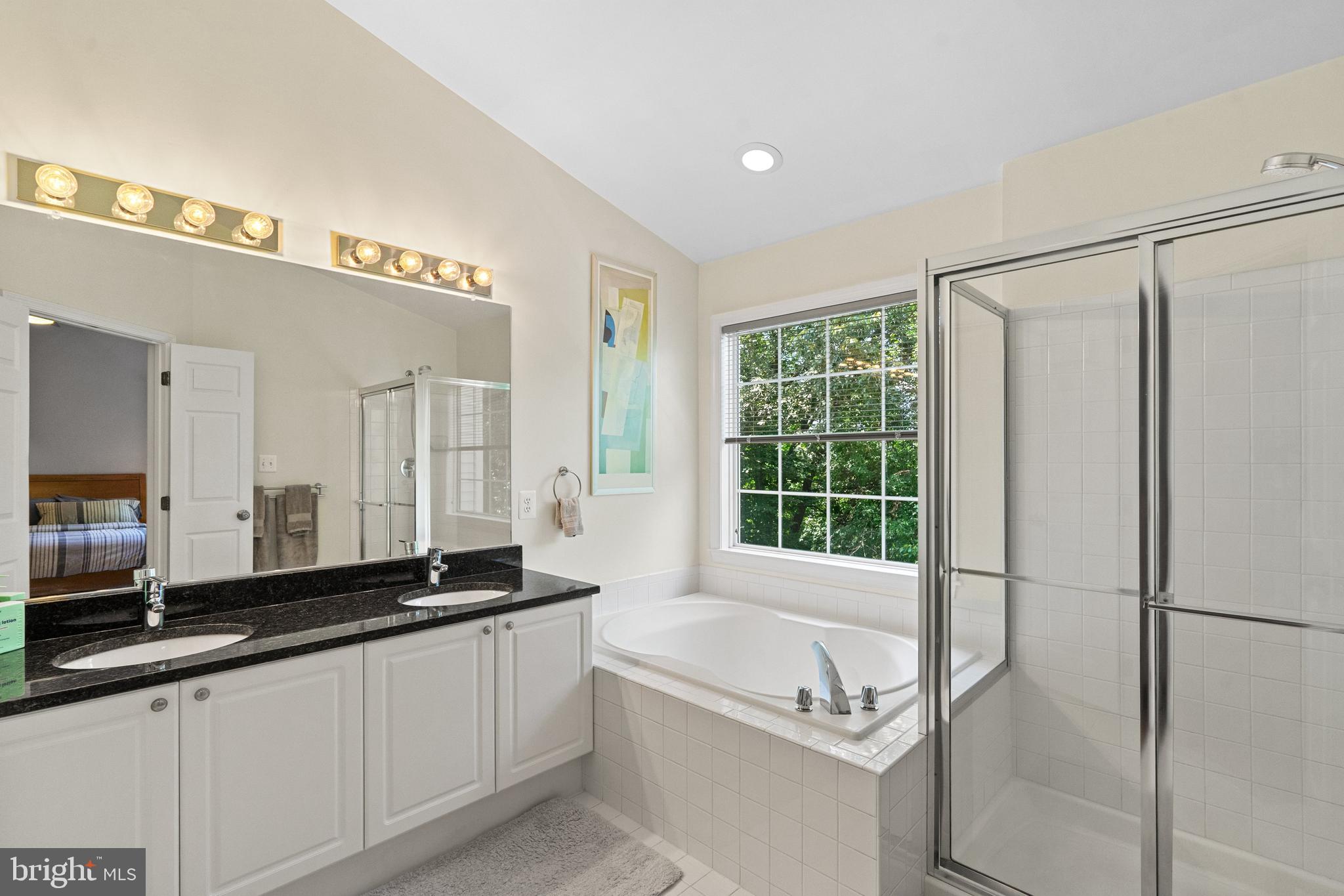 8512 Bells Ridge Terrace Potomac, MD 20854 - Photo 22 of 45 a spacious bathroom with a granite countertop tub sink and mirror