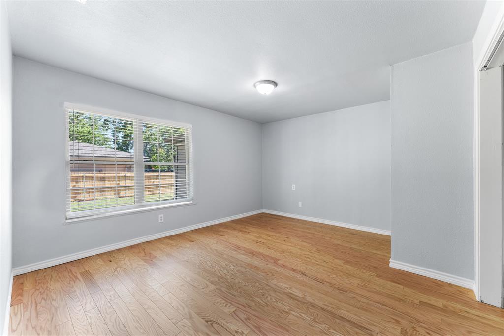 612 East 8th Street Kemp, TX 75143 - Photo 8 of 27 an empty room with wooden floor and windows